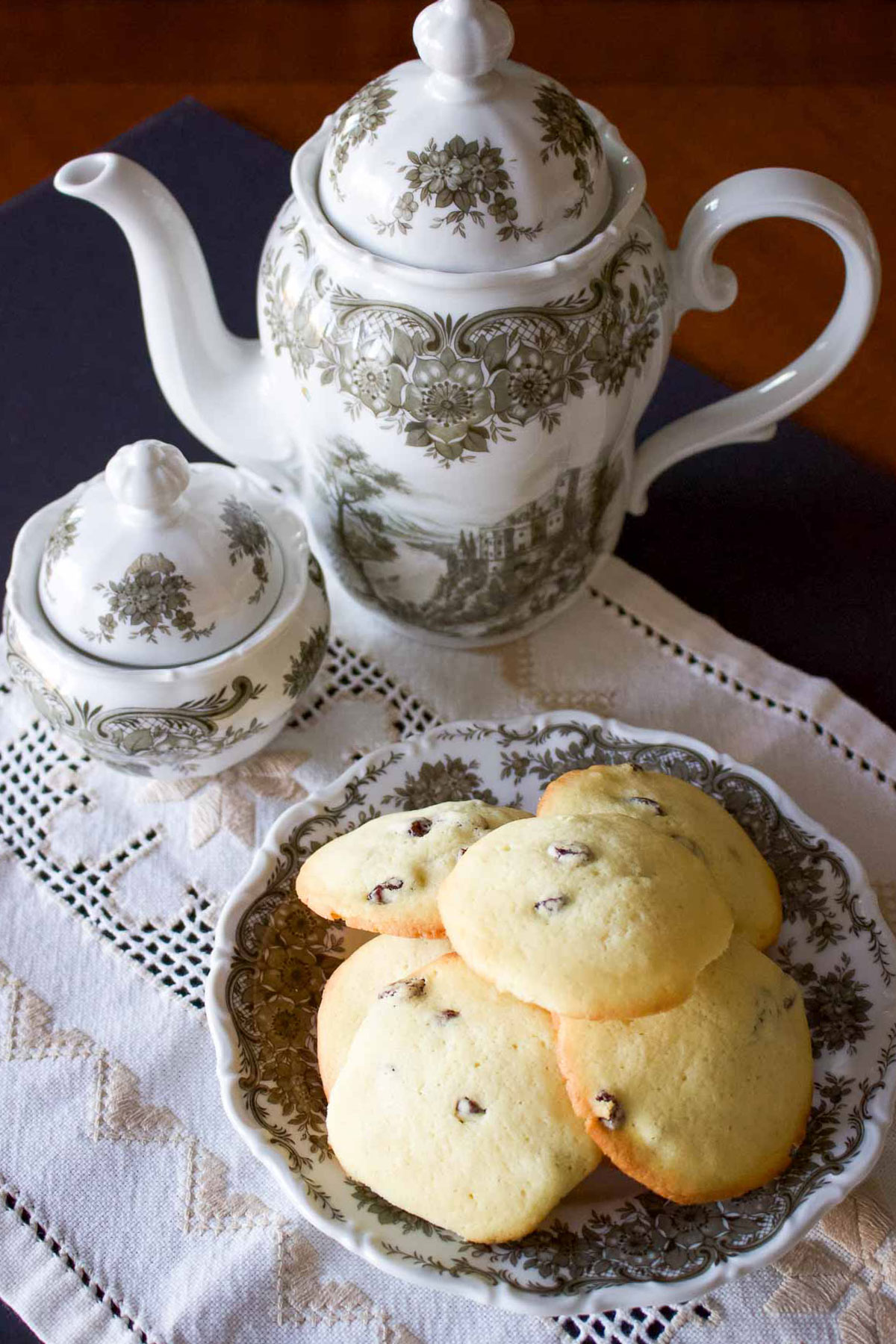 Rum Raisin cookies on a plate with teapot in the background.