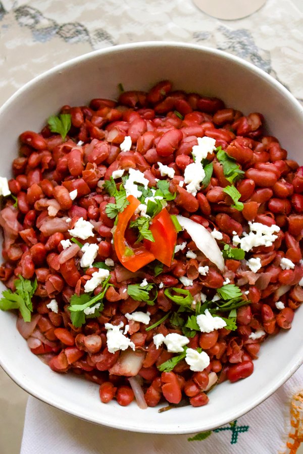 This is a basic authentic traditional Mexican beans recipe. The dish is nutritious, easy to make and so traditional that cannot miss from a respectable Mexican table. Authentic traditional Mexican beans in a white bowl with queso fresco and cilantro