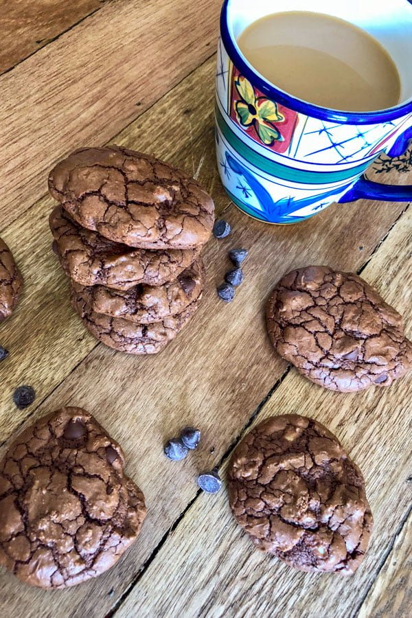 Easy Dark Chocolate Walnut Cookies-cookies and chocolate chips with a cup of coffee on a wood table
