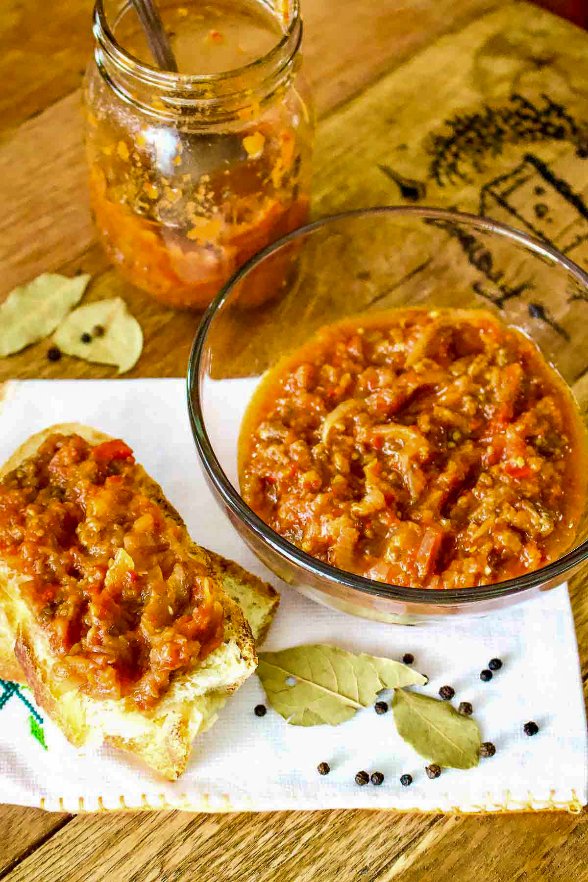 Zacusca vegetable spread with slice of bread and jar behind.