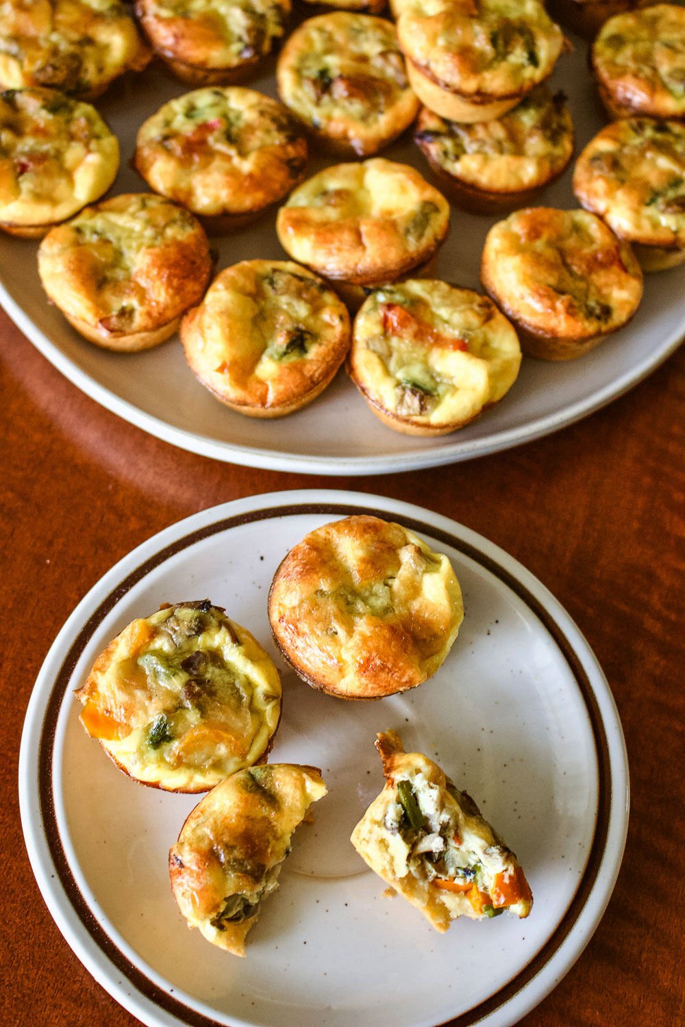 Mini vegetarian quiche on plate with platter in the background0
