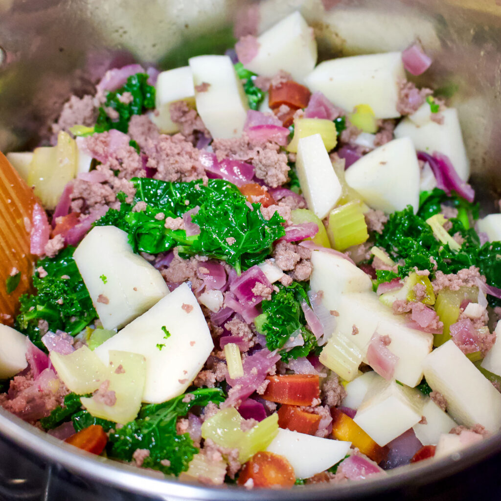 Diced vegetables with greens and potatoes cooking in the pot0