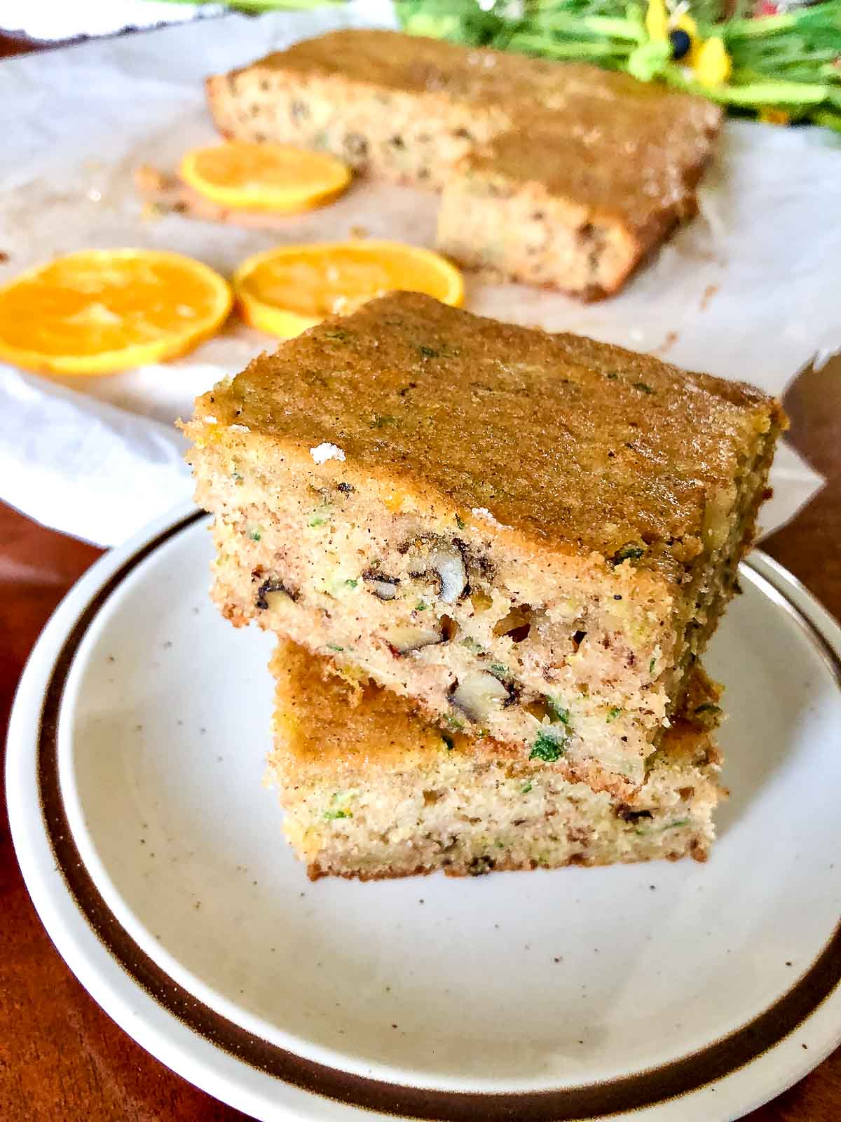 Zucchini Orange and Walnuts Cake is a delicious recipe that will soon make it to your recipe collection.If you love zucchini cake, this recipe is for you. Zucchini Orange Bread slices on a plate.