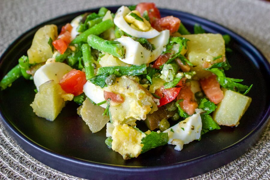 Green bean and potato salad- a delicious salad that can be served as a side dish next to your favorite cut of meat, or by itself for a light lunch or dinner. Green bean and potato salad- served on a dark plate