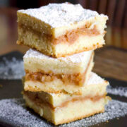 Stacked Slices of Apple Pie Romanian Style on a black plate.