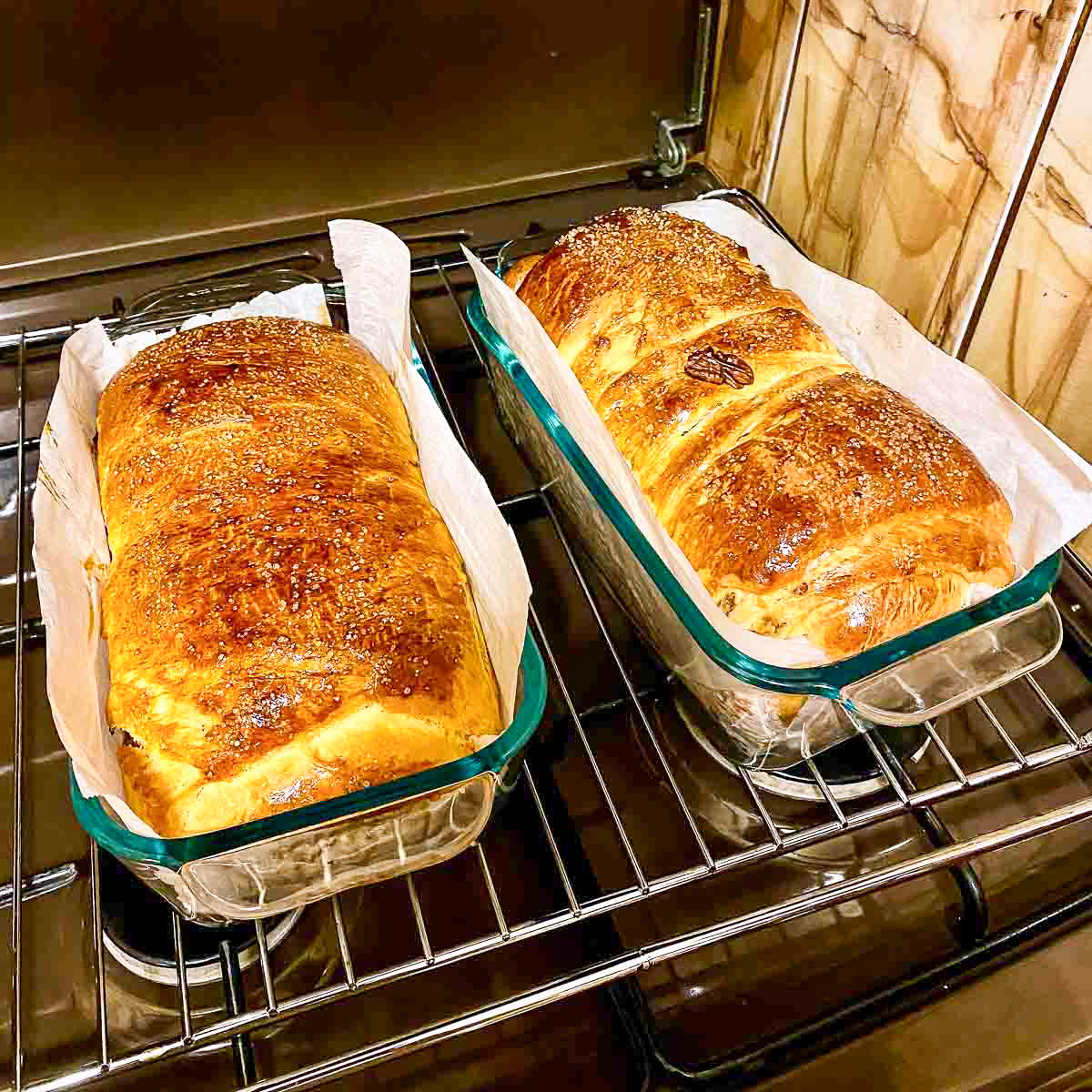 Baked cozonac in glass baking pans sitting in the oven.