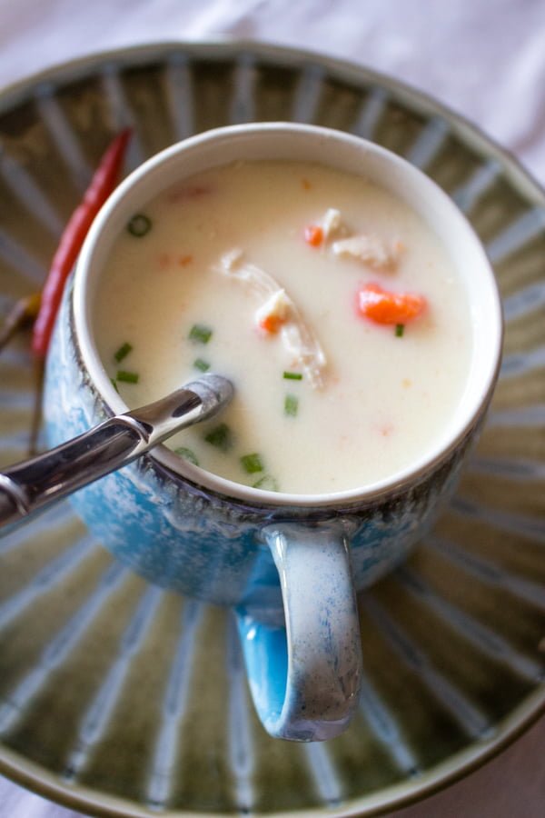 Chicken Soup With Sour Cream And Garlic is a Romanian soup also called "Ciorba Radauteana". Delicious and very nutritious. Chicken Soup With Sour Cream And Garlic -cup of soup on a blue and green plate