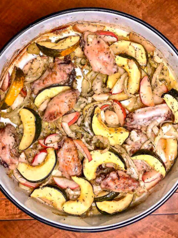 Sheet Pan Chicken with Acorn Squash, Apples And Fennel baked in a round baking tray.