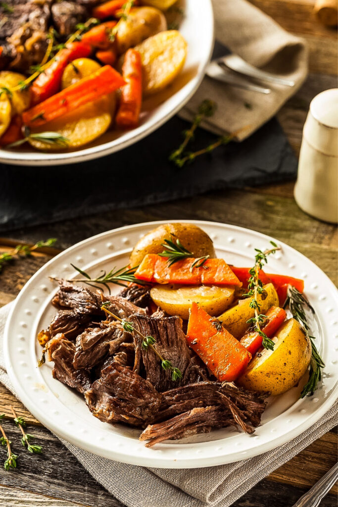 Pot Roast with vegetables on white platter0