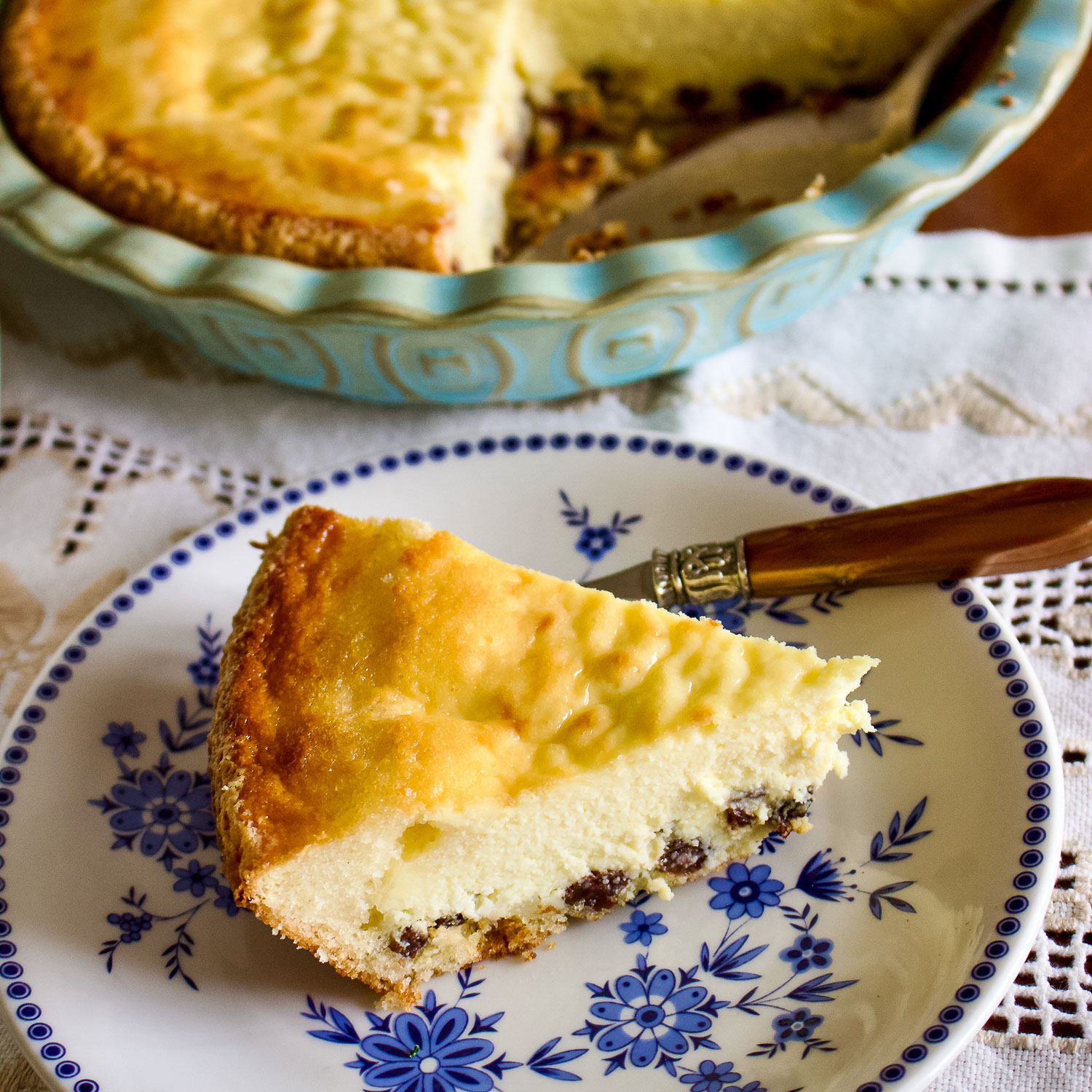 Romanian Easter Cheesecake sliced on a white and blue plate.