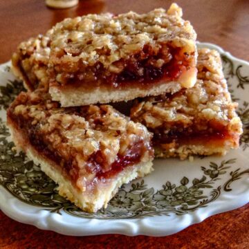 Walnut and Jam Bars on a white and black plate.