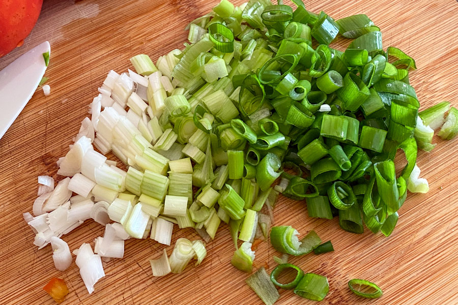 Chopped green onions on wooden board image.