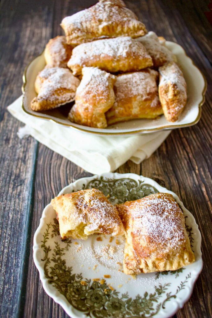 Sweet cheese pastries with powdered sugar on a platter0