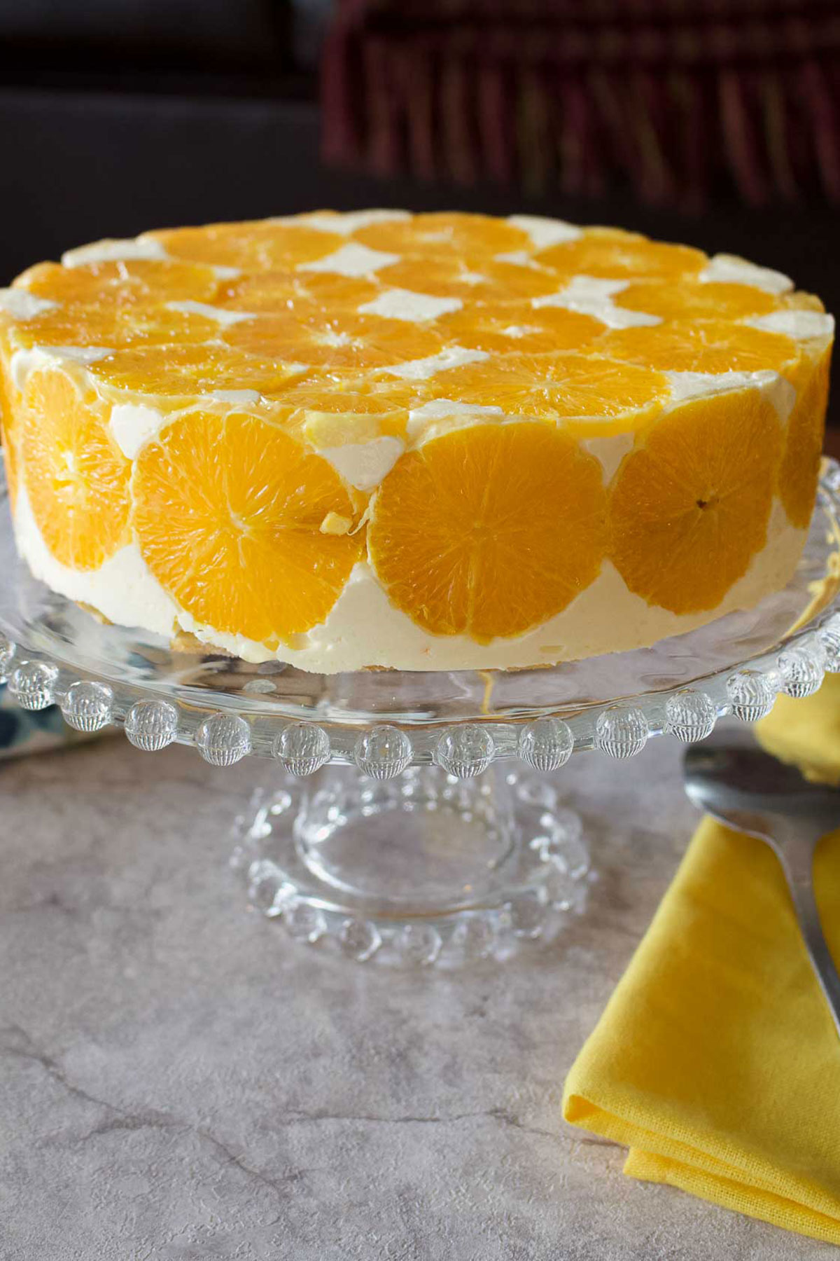 Orange Charlotte Cake on a glass cake support.