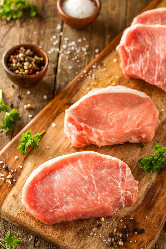 Boneless Pork Chops Raw on a cutting board