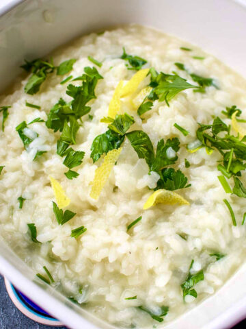 Lemon Rice in a serving bowl with herbs on top.