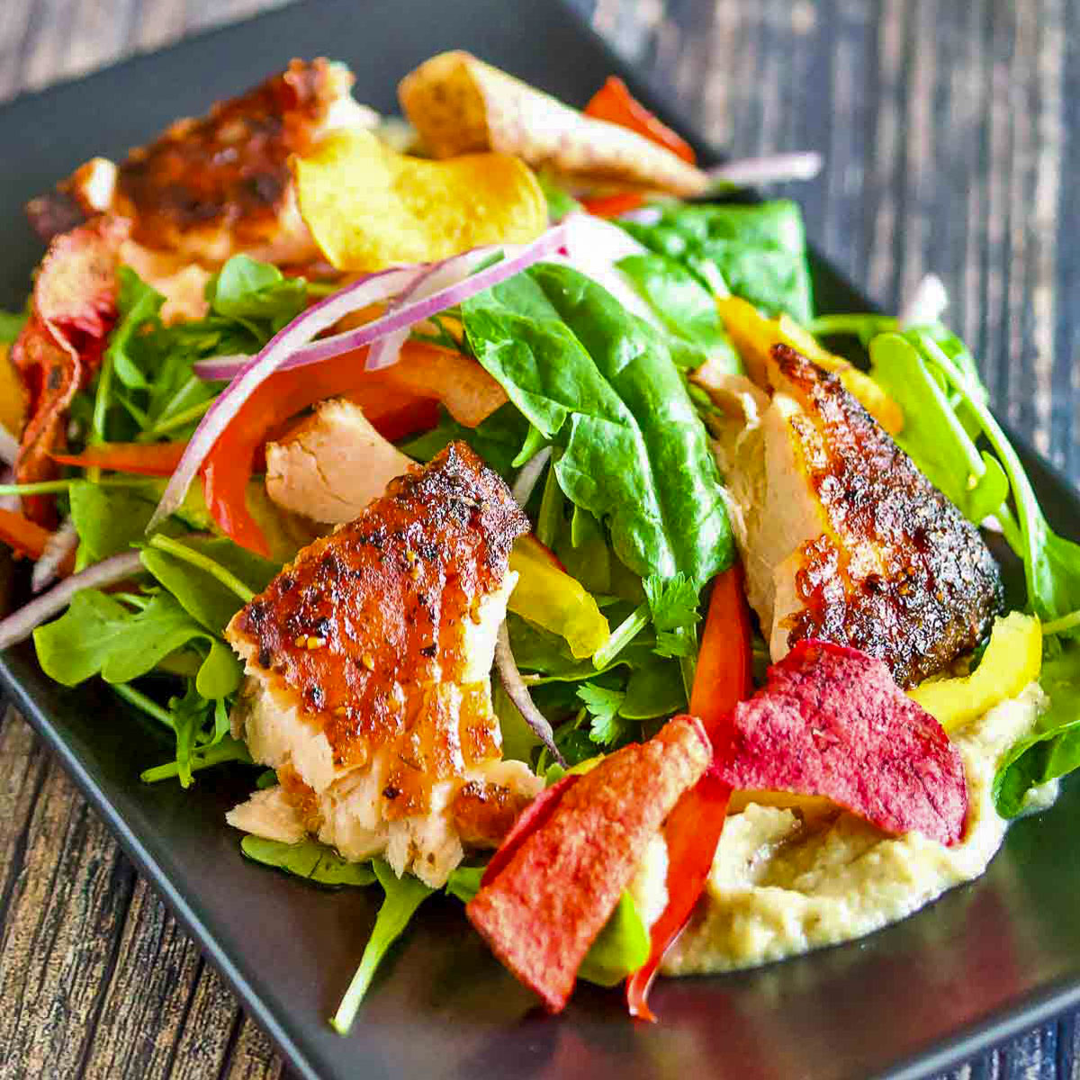 Baked salmon on a bed of greens with eggplant salad.