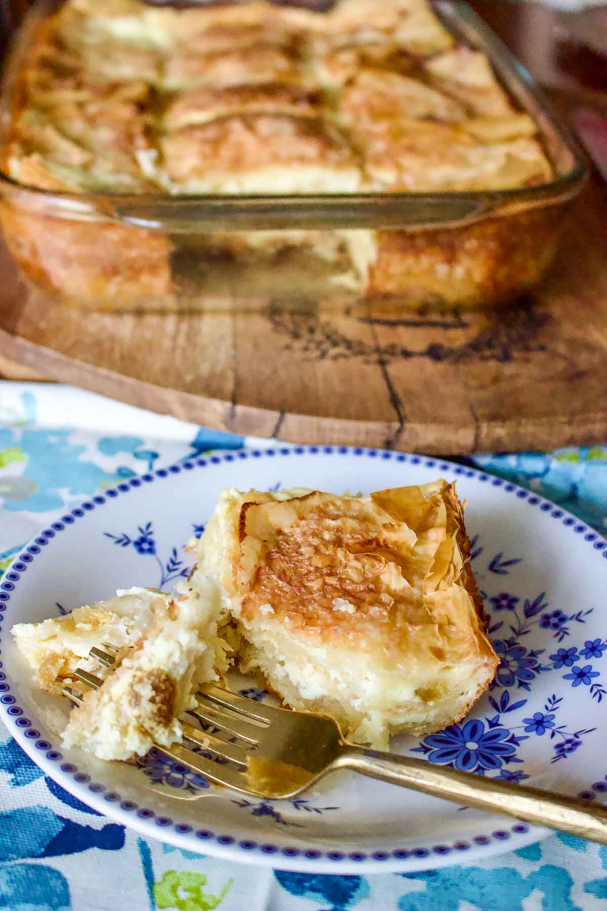 Sweet Cheese slab pie2626 Slice of cheese pie on a white and blue plate with fork.