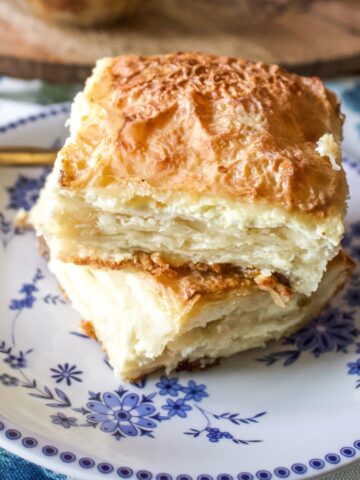 Sweet Cheese Slab Pie slices stacked on a white and blue plate.