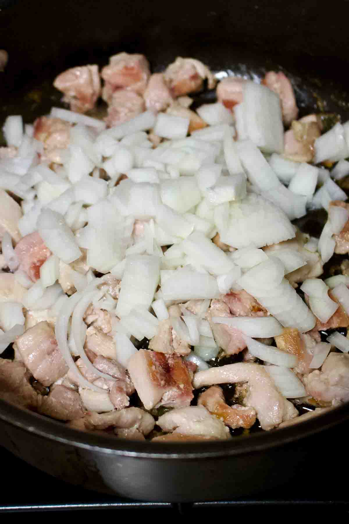 Chicken and onions cooking in the pan