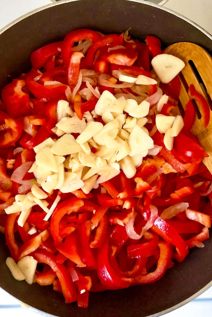 Peppers onions and garlic cooking in the pan