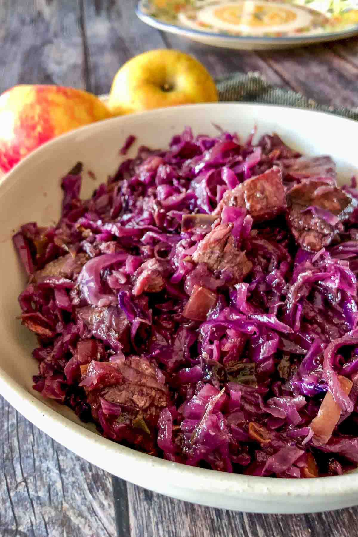 Celtic Red Cabbage With Pork And Red Currant Jelly9 Red cabbage with pork served in a white bowl.