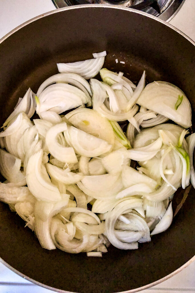 Sliced onion cooking in a dark pan