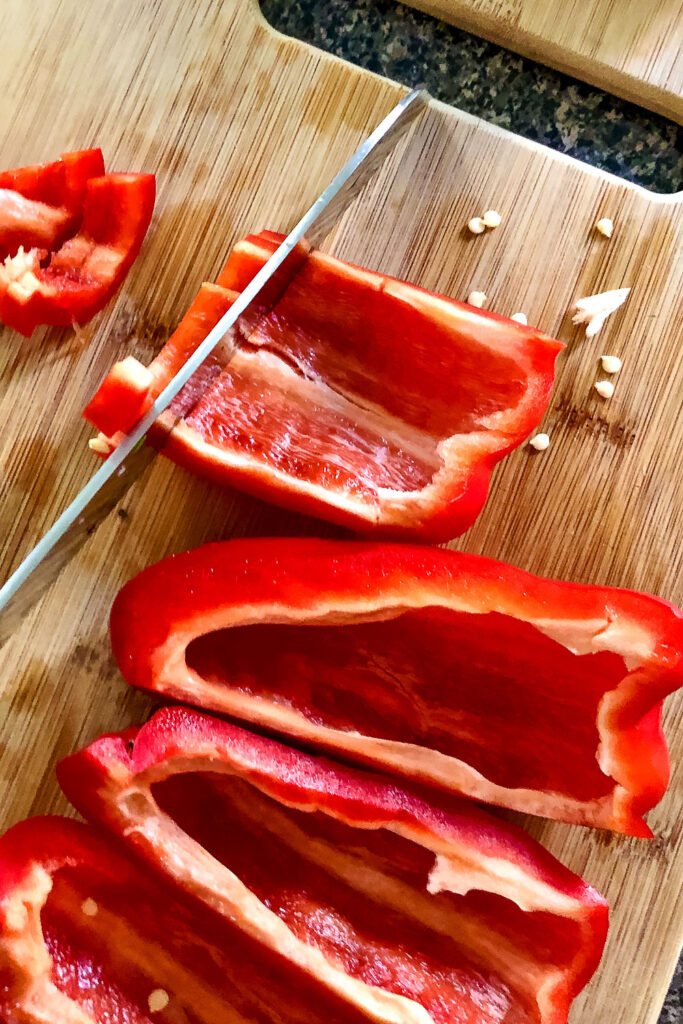 Sliced red bell pepper on wooden board
