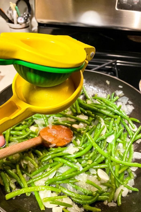 Green Beans Almondine Green Beans with Almonds55 Green beans with onions and garlic cooking in the pan with lemon juice