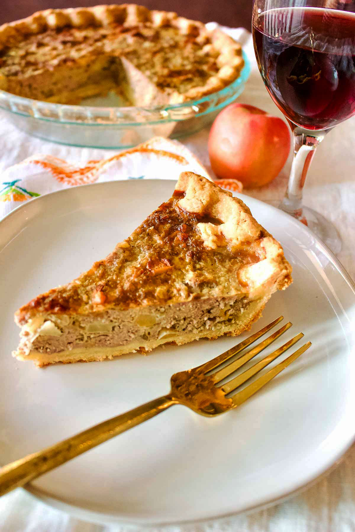 Slice of Pork Apple Pie With Cheddar on a white plate.