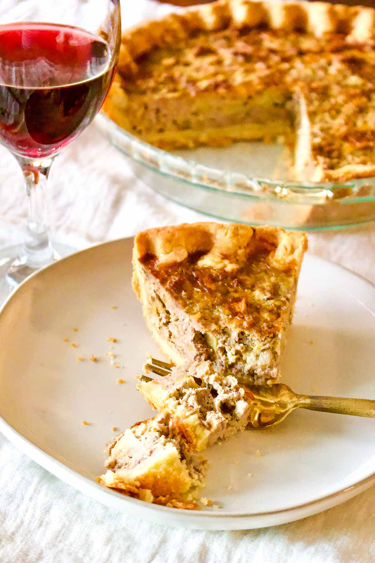 Slice of Pork Apple Pie With Cheddar served with red wine.