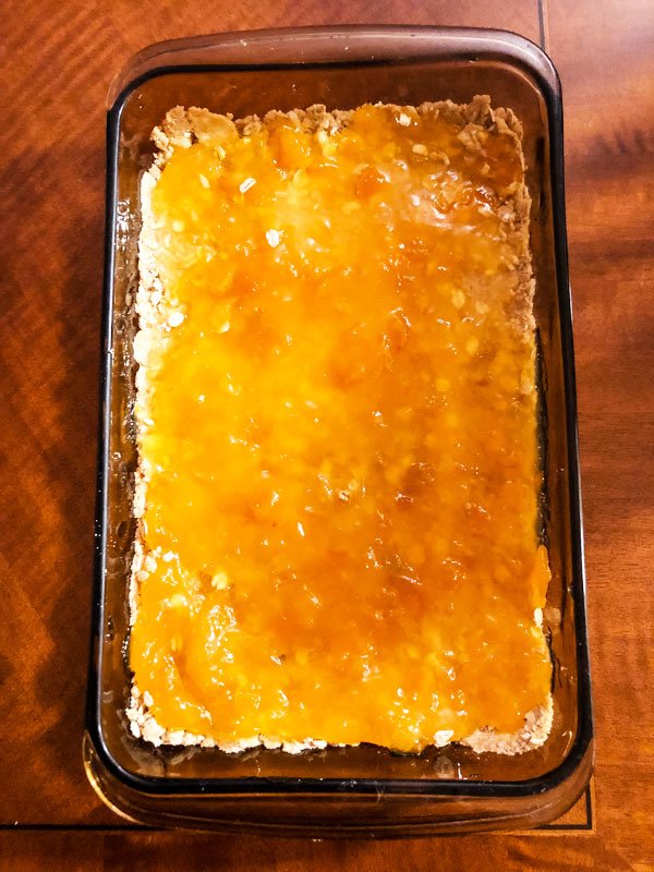 Layer of apricot jam on top of crust- Apricot Oat Bars