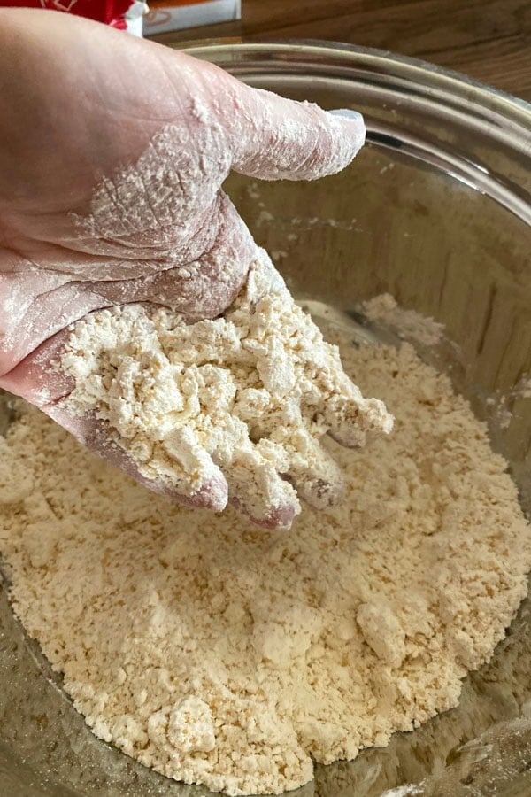 Mixing flour with butter to make scones.
