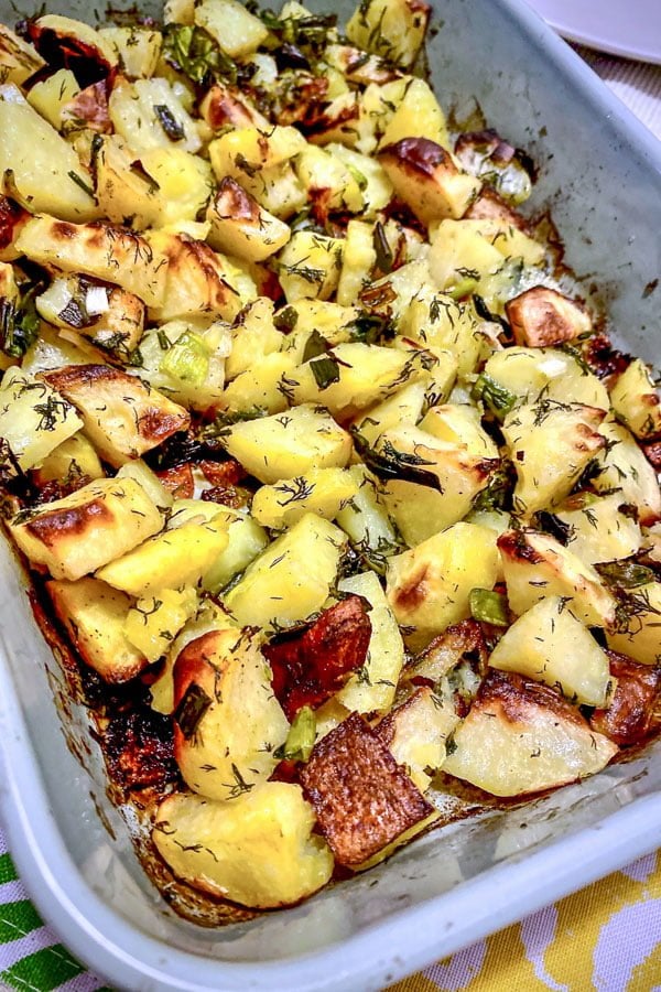 Roasted potatoes with green garlic and Dill in a baking dish