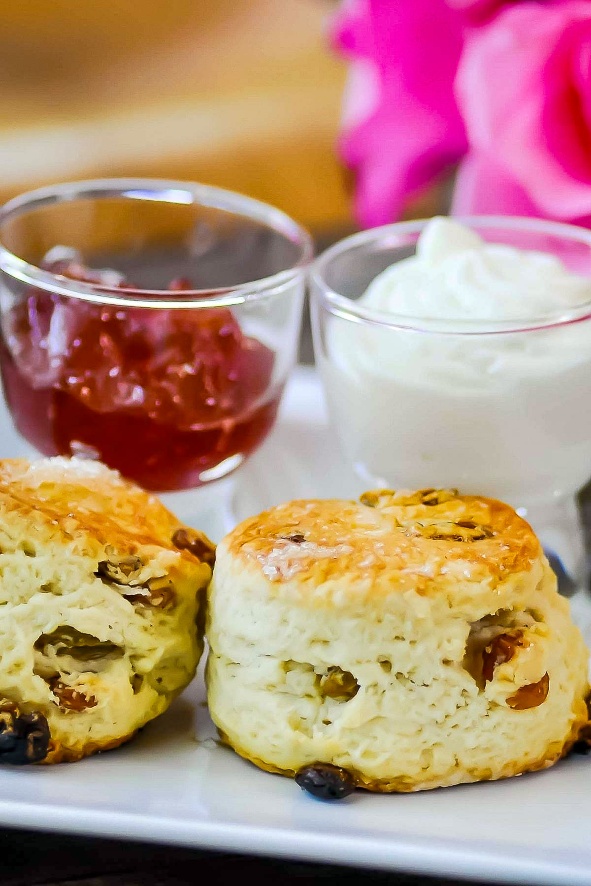Two scones served with jam and cream.