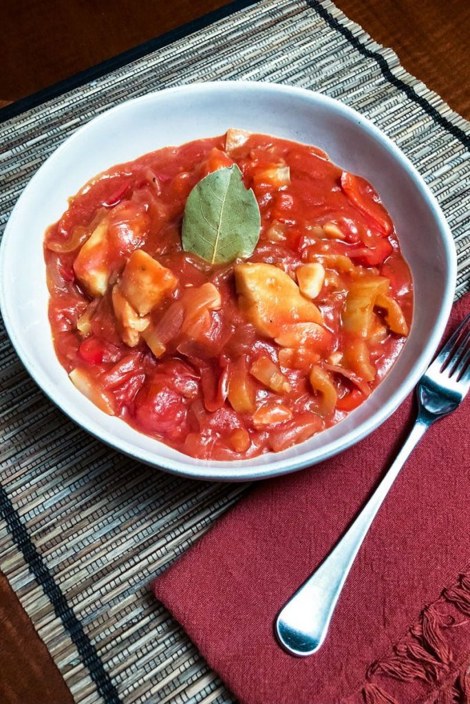 Spanish Cod In Tomato Sauce in a white bowl with fork
