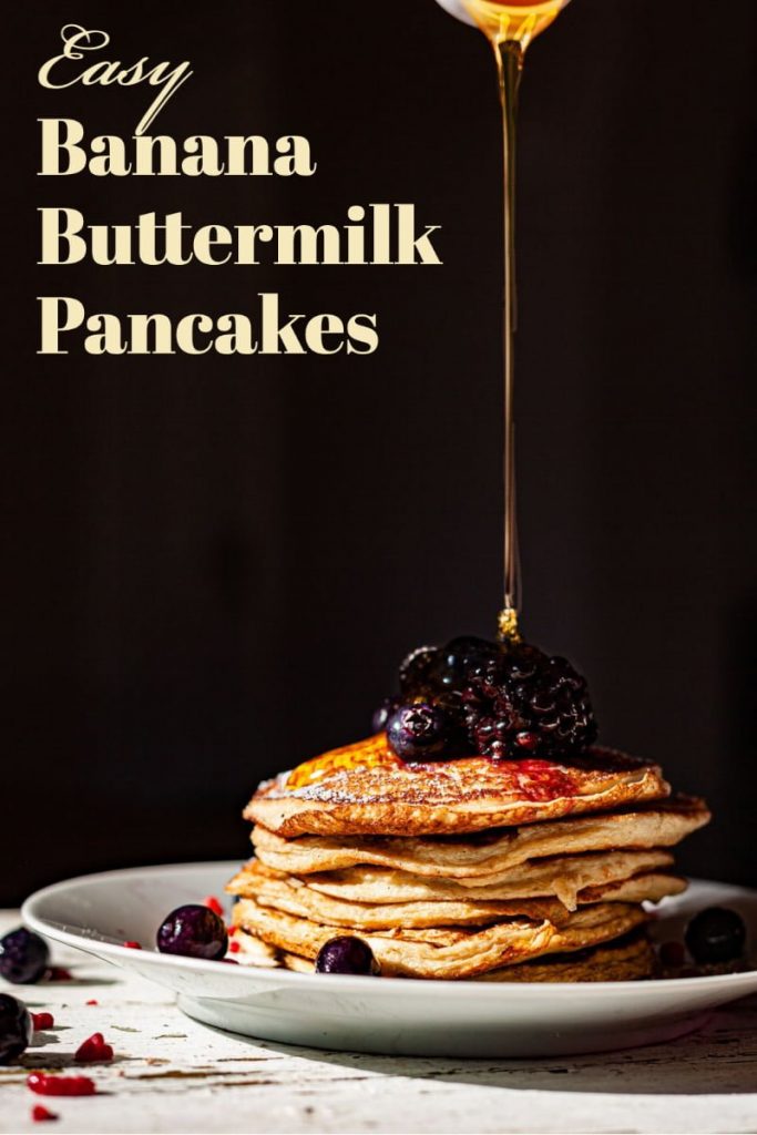 featured picture for Pinterest- pancakes on a white plate decorated with fresh blueberries and honey