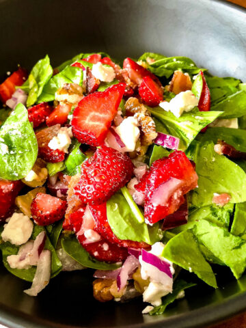 Spinach Strawberry Salad in a black serving bowl square image.