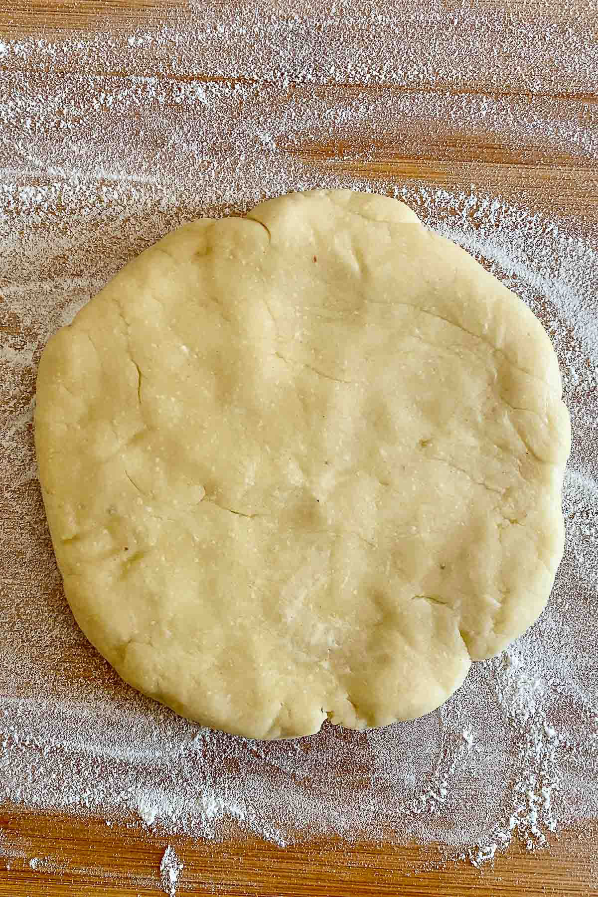 Rolling the crust pie on wooden surface.