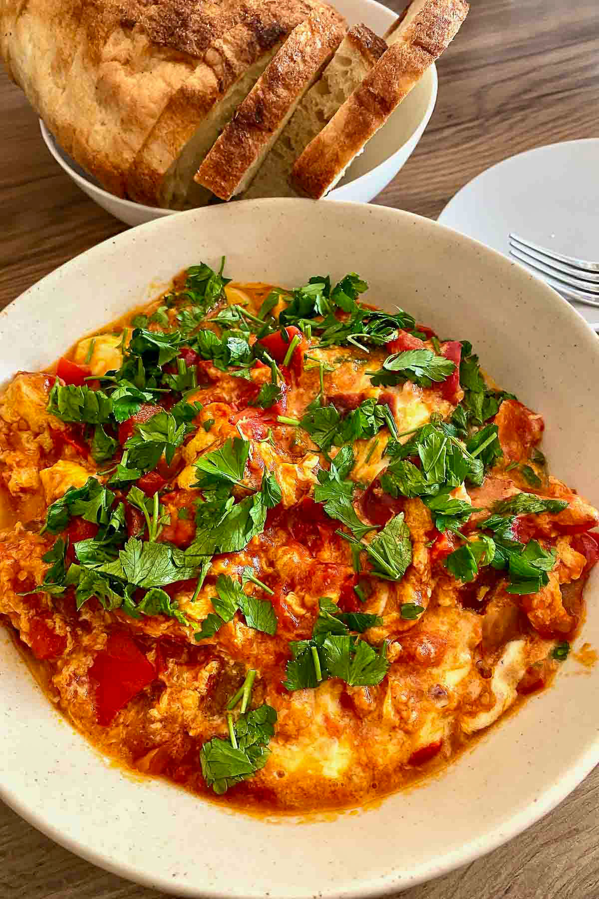 Balkan Pepper & Tomato Sauté with cheese and eggs in a white serving bowl.