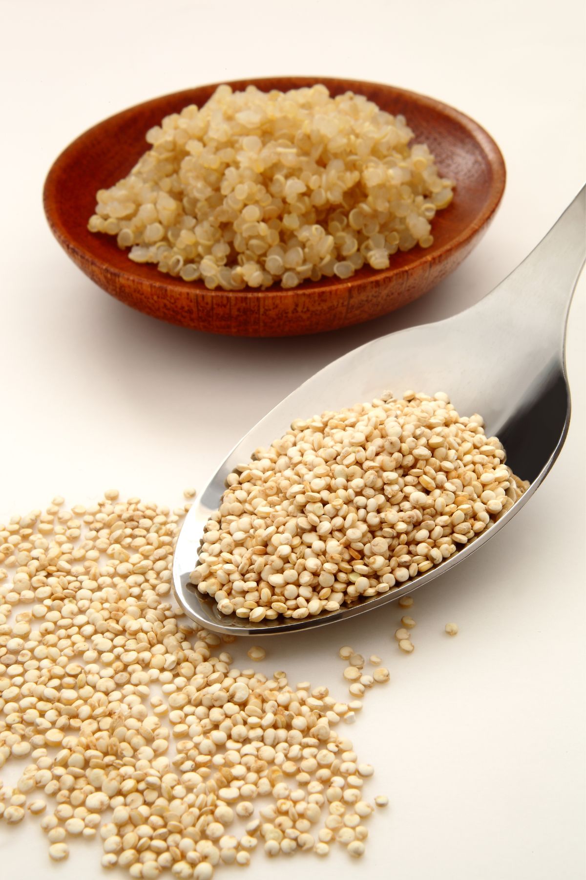 Cooked quinoa in a bowl and uncooked quinoa in a spoon