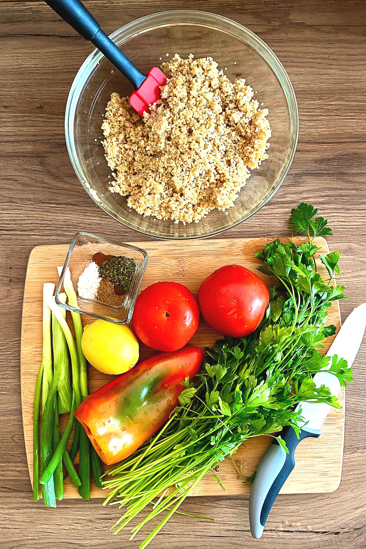 Ingredients for Quinoa Tabbouleh: cooked quinoa in a bowl, tomatoes, green onions, lemon, red pepper, parsley and spices