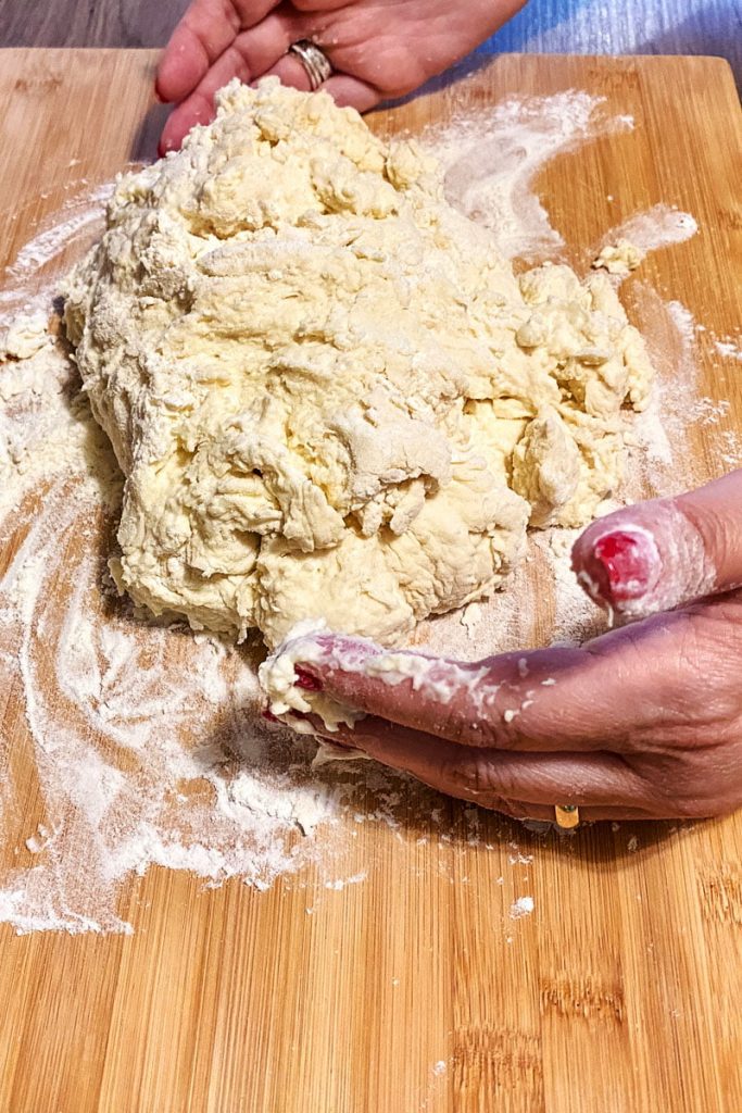 bread dough on a wooden cutting board dusted with flour