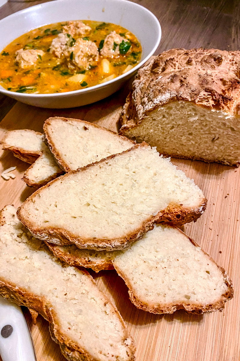No yeast bread Soda Bread sliced- with bowl of soup in the background