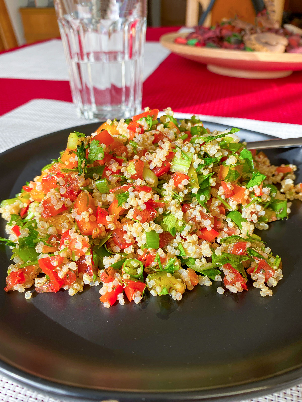 This quinoa tabbouleh salad uses beautiful, fresh ingredients that are easy to put together. Delicious and also gluten free. Delicious Quinoa Tabbouleh salad served on a black plate