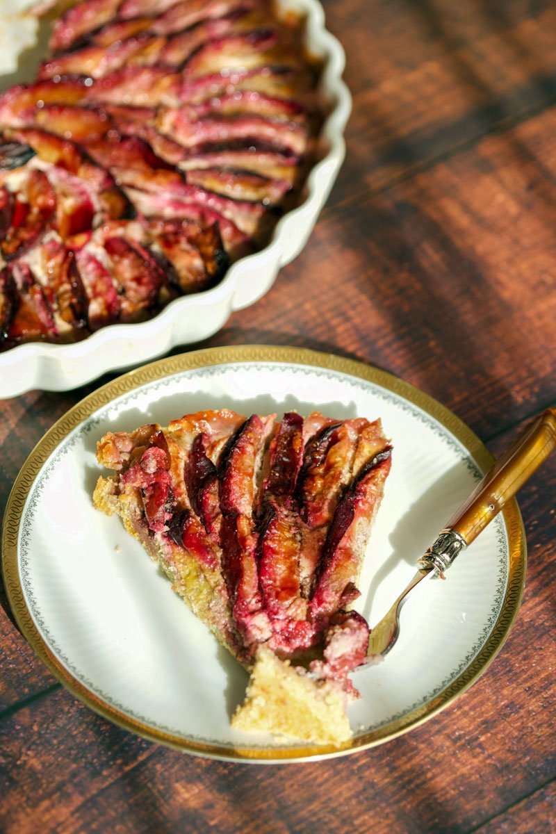 Plum tart slice on a plate with fork
