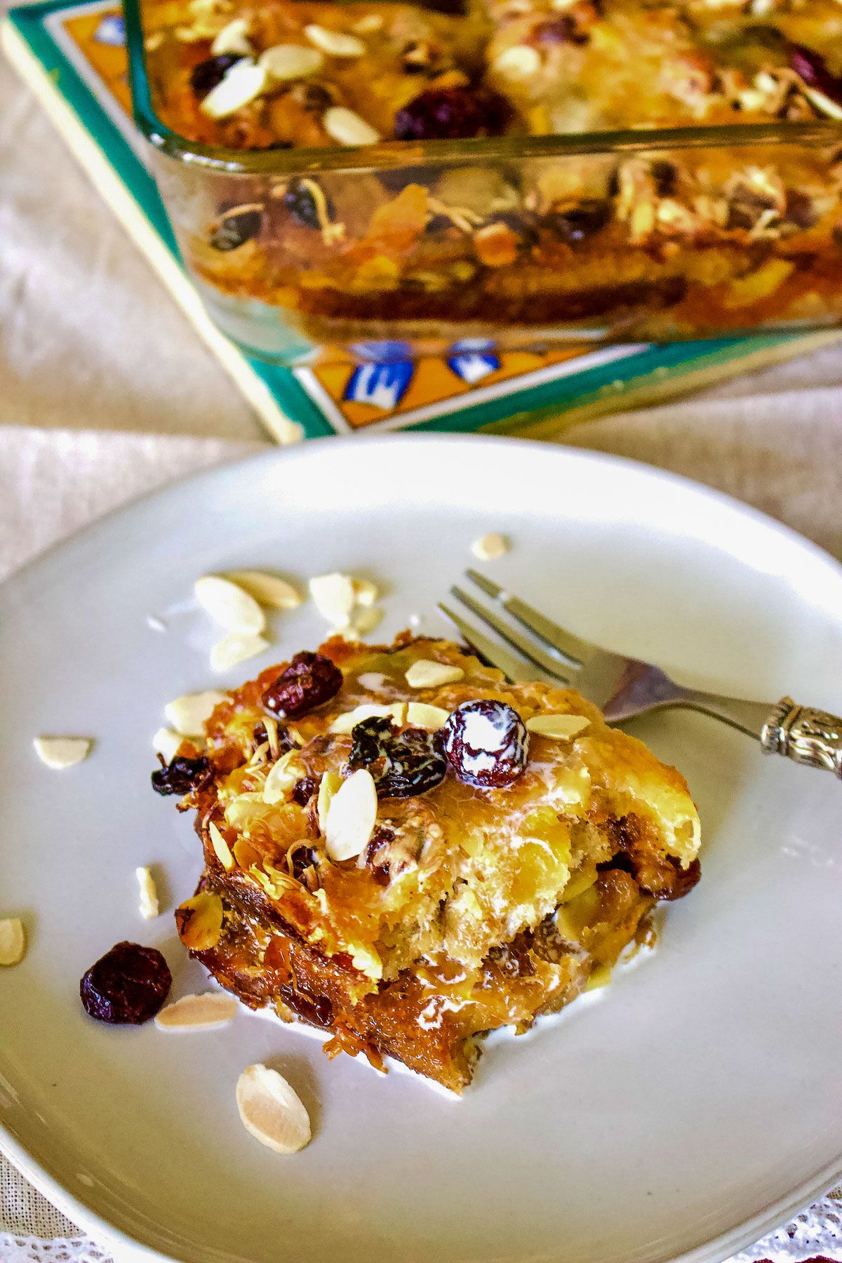 Authentic Mexican Capirotada- Bread Pudding is the Mexican version of the so popular bread pudding that you can find in many cuisines. This Capirotada is traditionally eaten during Lent, before Easter but you can also make it all year round. It is good for parties, holidays or Sunday meals in the family. Capirotada on plate decorated with almonds