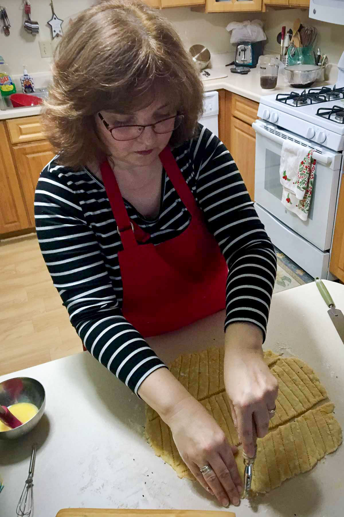 The Bossy Kitchen owner cutting the dough for cheese straws.