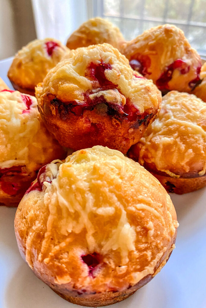 cranberry muffins stacked on a plate next to a window1