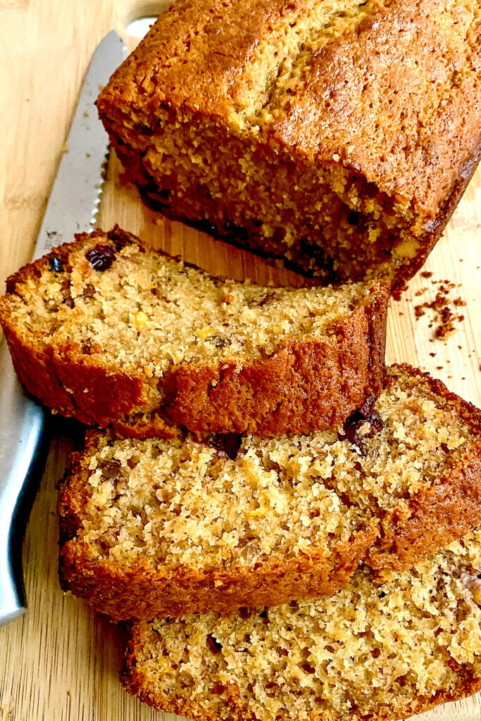 Cranberry Orange Banana Bread slices on wooden board0